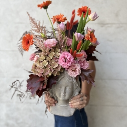 Composition of Pink and Orange Flowers in a Face Vase