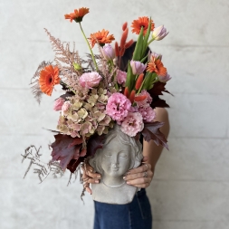 Composition of Pink and Orange Flowers in a Face Vase