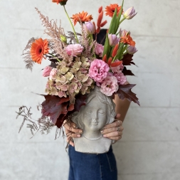 Composition of Pink and Orange Flowers in a Face Vase