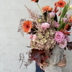 Composition of Pink and Orange Flowers in a Face Vase