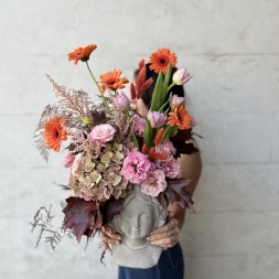 Composition of Pink and Orange Flowers in a Face Vase