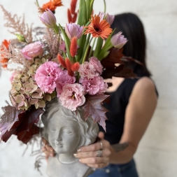 Composition of Pink and Orange Flowers in a Face Vase