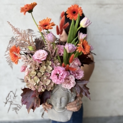 Composition of Pink and Orange Flowers in a Face Vase